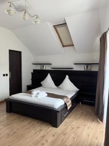 a bedroom with a large bed with a black headboard at Pensiunea Carina in Bran +28 photos
