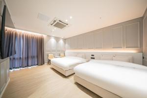 a hotel room with two beds and a window at Hound Hotel Mokpo Peace Plaza in Mokpo