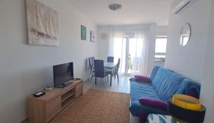 a living room with a blue couch and a tv at Apartmani Mentha & Lipa in Novi Vinodolski