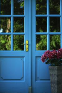 uma porta azul com um vaso de flores num cesto em Hotel Sundblick em Altefähr