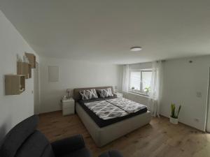 a white bedroom with a bed and a window at Gemütliches Apartment in Dahlbruch zentral-ruhige Lage in Hilchenbach