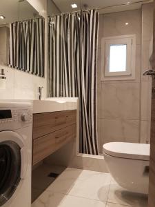 テッサロニキにあるLaura White Tower Apartmentの洗面台と洗濯機を備えたバスルーム