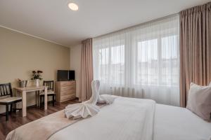 a bedroom with a large white bed with a window at Hotel Brixen in Prague