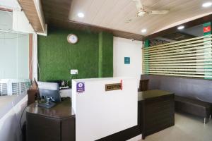 ein Büro mit einem Schreibtisch und einer Uhr an der Wand in der Unterkunft Hotel O Kuber 7 in Zirakpur