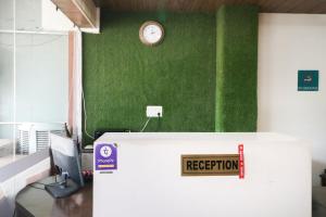 an office with a reception desk with a clock on the wall at Hotel O Kuber 7 in Zirakpur