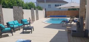 a patio with chairs and a pool and an umbrella at le jardin de Marie in Le Grau-du-Roi