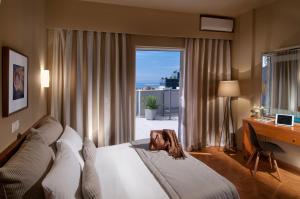 una mujer acostada en una cama en una habitación de hotel en Hotel Delfini, en Pireo