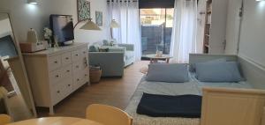 a living room with a couch and a tv at le jardin de Marie in Le Grau-du-Roi