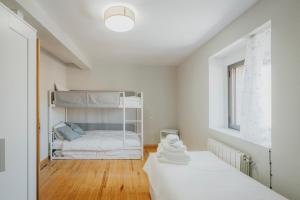 a white bedroom with a bunk bed in it at La Cabaña de Cascajares in Cascajares de la Sierra