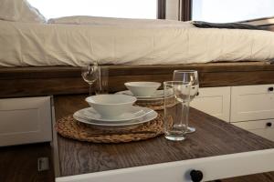 a table with two glasses and plates on a bed at Dolce Casa 1 by Tiny Away in Arezzo +15 photos