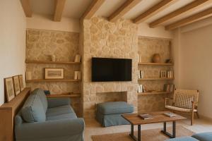 a living room with a couch and a tv at Village Escape House by CorfuEscapes in Lefkimmi