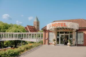 a hotel building with a sign in front of it at CASCADA Rheine by Hackmann in Rheine