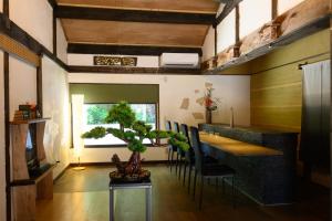 高松Kino的一间配备有桌椅和植物的餐厅