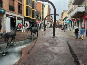 two horses are standing in the middle of a street at Libertad 45 in Torrejón de Ardoz