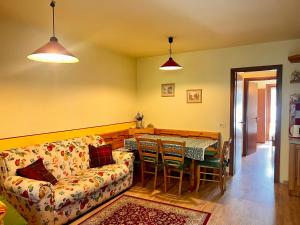 a living room with a couch and a table at Solarium e area Giochi - Vicino ad Asiago - Garage in Roana