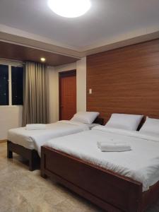 Una habitación de hotel con tres camas en una habitación. en Gibraltar Inn, en Baguio