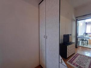 a living room with a cabinet and a television and a room at Apartment house Nena in Krk