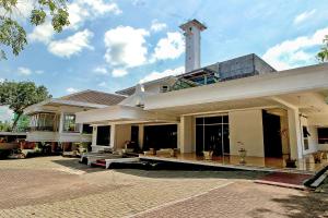 ein großes weißes Gebäude mit einem Uhrenturm auf der Spitze in der Unterkunft OYO 2360 Hotel Rio in Bengkulu