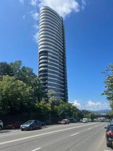 a tall building with cars parked on the side of a road at Sunset Studio - 12th Floor in Cluj-Napoca