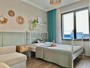 Un dormitorio con una cama y un sofá y una ventana. en Green Roof Villa - Sea View & Large Garden, en Gökçeada