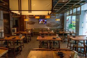 an empty restaurant with wooden tables and chairs at Evergreen Place Siam by UHG in Bangkok