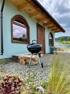 a grill sitting in front of a house at Domki Nad Bocianim Gniazdem in Bukowiec