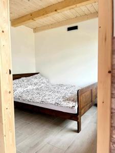 a bed in a room with a wooden frame at Domki Nad Bocianim Gniazdem in Bukowiec