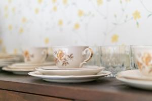 a table with white cups and plates and glasses at Majatalo Kukkasrinne in Lahti
