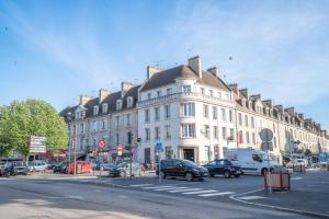 un grande edificio bianco con auto parcheggiate in una strada cittadina di Casa Gauda, Jacuzzi, détente et sérénité a Falaise