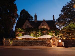 an old house with umbrellas in front of it at Old Parsonage Hotel in Oxford