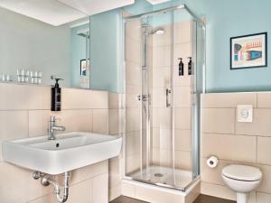 a bathroom with a sink and a shower at Garner Hotel Berlin - Schöneberg by IHG in Berlin +83 photos
