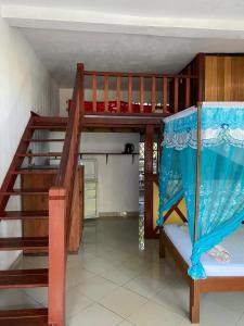 a bunk bed in a room with a staircase at Studio Cannelle - À deux pas de la plage Nosy Be in Nosy Be