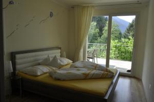 a bedroom with a bed with a view of a balcony at Ferienwohnungen Niederhof in Lana +65 photos