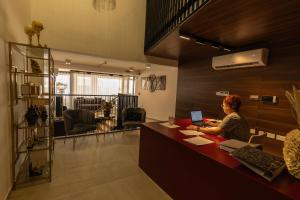 a woman sitting at a desk with a laptop at Lokali Rooms in Il-Gżira