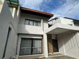 una casa blanca con un edificio en Bukit Damansara Terrace, en Kuala Lumpur