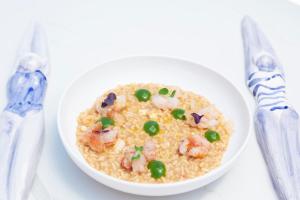 a bowl of rice with shrimp and peas on a table at Pagoda Lifestyle Hotel in Ischia