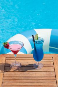 two cocktails on a wooden table next to a swimming pool at Pagoda Lifestyle Hotel in Ischia