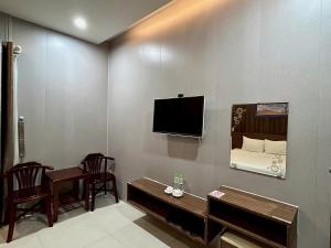a room with a bed and a tv on a wall at BeSea Hotel in Danang