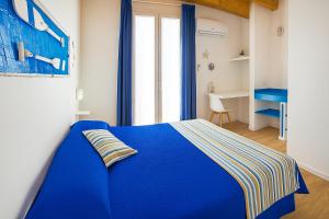 a blue bed in a white room with a window at B&B 106 Maison de Charme in Mola di Bari +41 photos