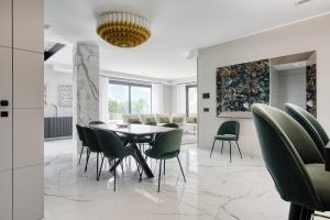 a dining room with a table and green chairs at Altavista Roero in Monteu Roero