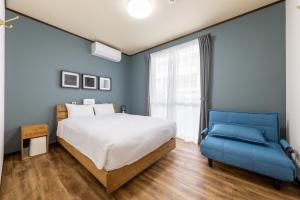a bedroom with a bed and a blue couch at Machinaka Miyako in Miyako-jima