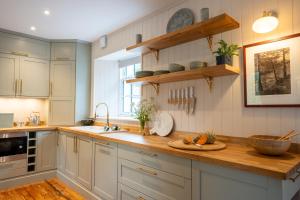 a kitchen with white cabinets and a wooden counter top at Penninghame Estate - Earl's Library in Challoch