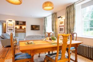 a living room with a wooden table and chairs at Penninghame Estate - Earl's Library in Challoch