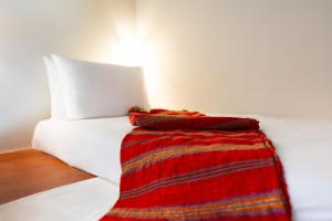 a white bed with a red blanket on it at Via Vasileia 6 in Kattavía