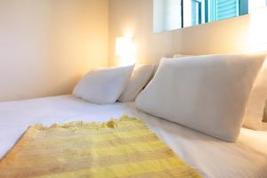 a bed with white pillows and a blanket on it at Via Vasileia 6 in Kattavía