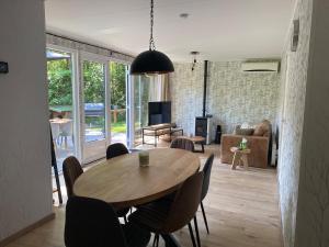 a dining room and living room with a table and chairs at Luxury bungalow Woldzicht in Appelscha
