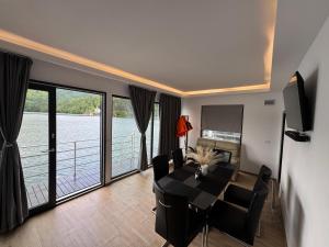 a dining room with a table and a view of the water at Sia Lake View Bicaz in Ceahlău