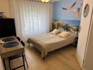 una camera da letto con un letto con uccelli sul muro di Pokoje gościnne Kulesza a Łeba