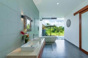 a bathroom with three sinks and a tub at Alam Dana Ubud in Ubud +37 photos