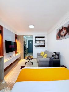 a living room with a yellow bed and a couch at my cozy place in Nairobi
